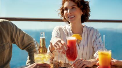 Eine Frau trinkt Cocktails auf einer Mein Schiff Kreuzfahrt, Mein Schiff Premium-Inklusivleistungen