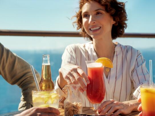 Eine Frau trinkt Cocktails auf einer Mein Schiff Kreuzfahrt, Mein Schiff Premium-Inklusivleistungen