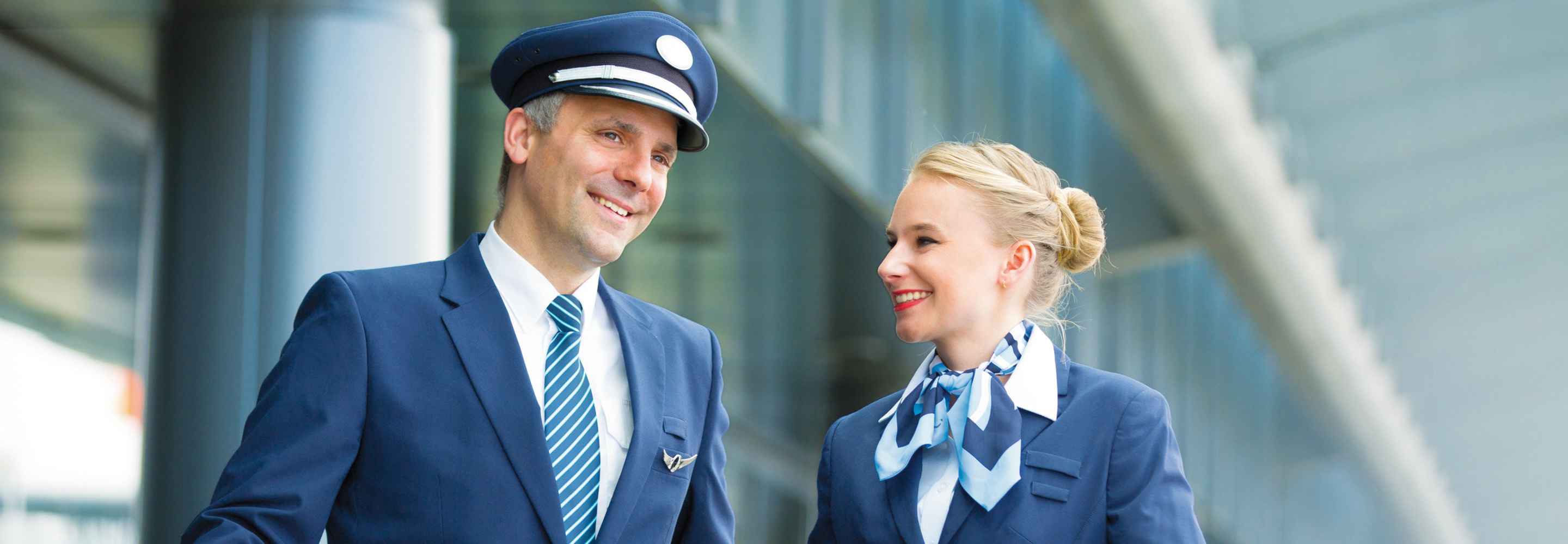 Ein Pilot und eine Flugbegleiterin in einem Flughafengebäude