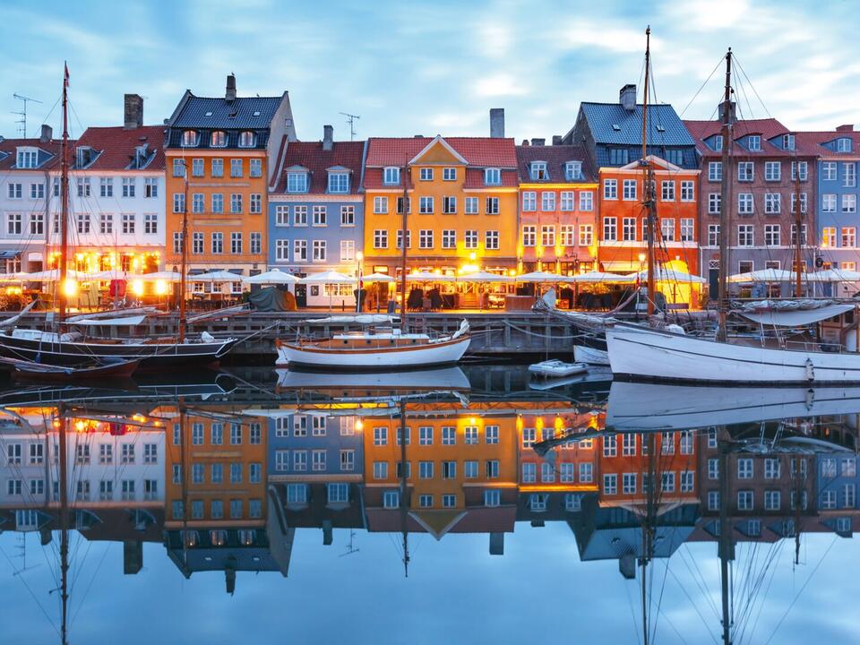 Bunte Häuser am Wasser mit Booten davor in Kopenhagen bei Dämmerung, Mein Schiff Ostsee Kreuzfahrt